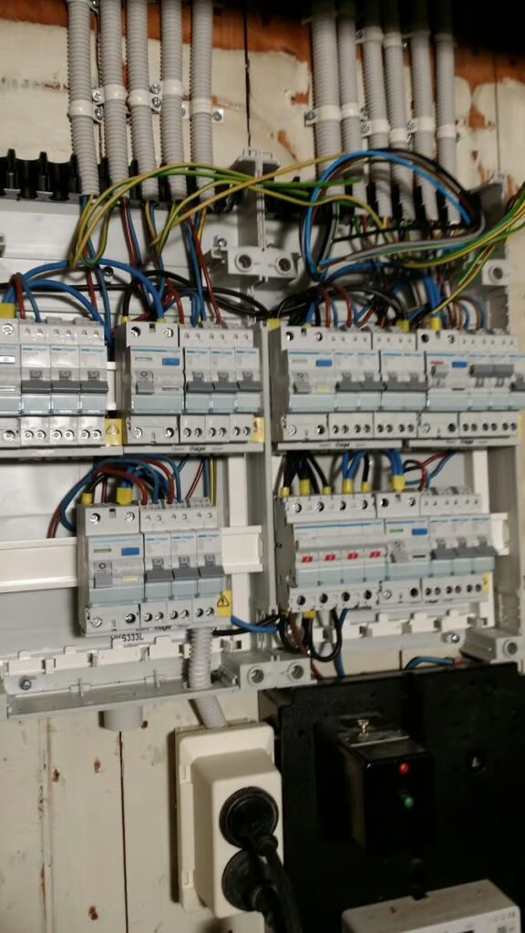 Geopende Franse meterkast met elektrische leidingen, aansluitstrips en modulaire beveiligingen